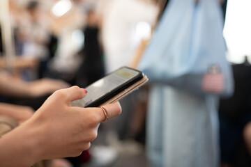 電車内でスマートフォンを操作する女性の手