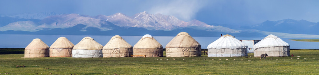 Traditional yurt camp at the Song Kul lake plateau in Kyrgyzstan, showcasing the nomadic lifestyle with portable felt tents used as accommodations.