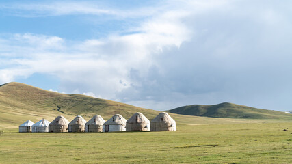 Traditional yurt camp at the Song Kul lake plateau in Kyrgyzstan, showcasing the nomadic lifestyle with portable felt tents used as accommodations.
