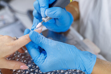 Close-up of female hands getting manicure in spa salon. Cosmetic procedure. Nail care.