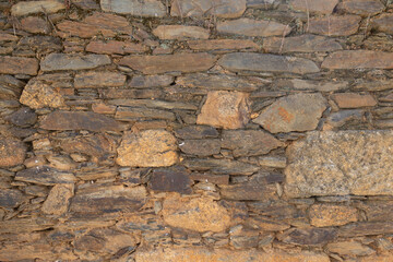  rustic stone wall showcasing the natural textures and earthy tones of the stacked rocks. The detailed masonry and rugged surface make this image perfect for architectural or construction-related