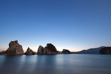 夜明け前の浄土ヶ浜、薄明の空と奇岩の幻想的風景