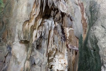 Inside view of cave with  a lot of vertical stalactites and stalagmites. Speleology destination