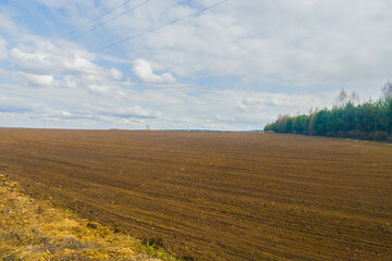 Fototapeta premium Spring autumn season countryside works.Harvesting farming wheat.Agricultural plowed field on sunny daytime.