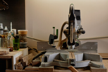 Well-organized woodworking station featuring an electric sawmill device and various tools neatly arranged on the workbench creating an efficient workspace for carpentry enthusiasts