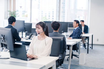 ヘッドセットをつけて話す若いビジネスウーマン