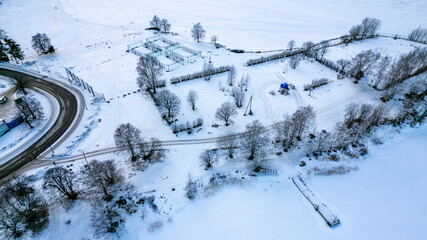 drone aerial view over Helsinki sea line in winter time - beach and marina covered with snow
