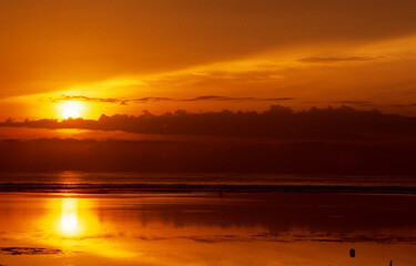 golden orangener Himmel am Strand des Mittelmeers mit dunklen Wolken bei Sonnenuntergang