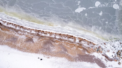 drone aerial view over Helsinki sea line in winter time - beach and marina covered with snow