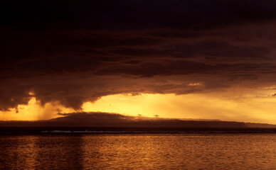 golden orangener Himmel am Strand des Mittelmeers mit dunklen Wolken bei Sonnenuntergang