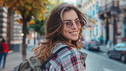Fototapeta premium Fashion. Young stylish woman walking on the city street looking back camera smiling playful