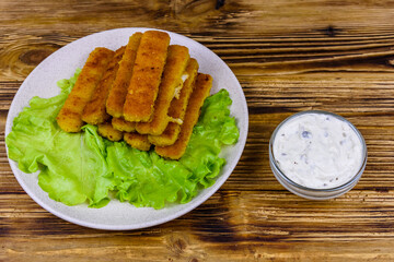 Baked fish sticks and lettuce leaves in a plate