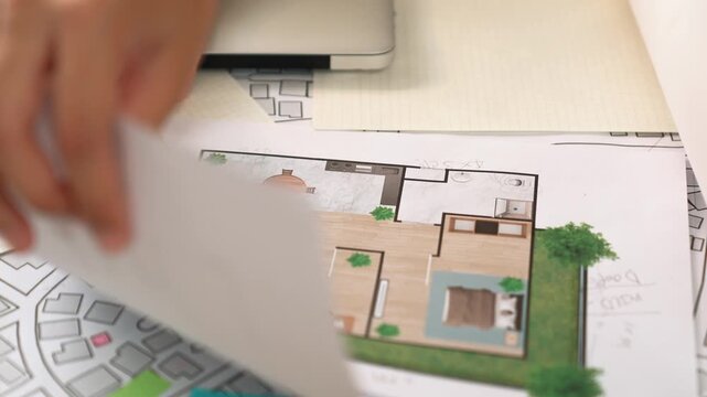 Professional engineer team discussion about house design on meeting table with architectural equipment and building blueprint scatter around at modern office. Focus on hand. Closeup. Delineation.