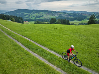 Obraz premium pretty senior woman riding her electric mountain bike in the Allgaeu mountains near Oberstaufen and Stiefenhofen, Bavaria, Germany