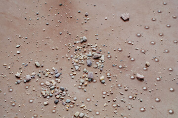 Close up of gravel strewn on merry-go-round floor with floor rivet bump texture