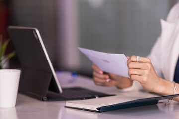 Fototapeta premium A female employee holds a white envelope to give to her manager after she decides to quit to pursue her own business. The concept of resigning from a full-time employee to start a private business