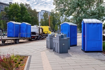 Biotoilets on the city street. Maintenance of biotoilets. Septic tank truck carrying portable toilets.