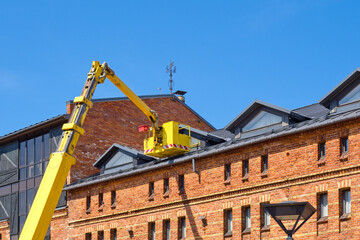 Roof repair from a lift. Safe work at height. Builders work from a telescopic lift.
