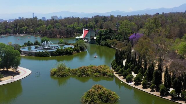 Toma a&eacute;rea en un d&iacute;a soleado en Chapultepec, Ciudad de M&eacute;xico, vista a los lagos, fuentes, corredores, y el bosque. Personas disfrutan de paseos en bote y actividades recreativas al aire libre. 