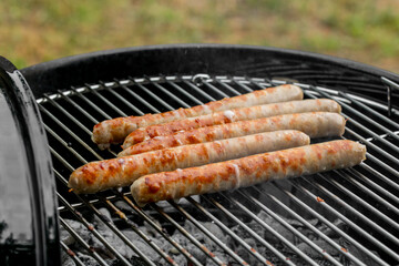 Grilled sausages on a smoky barbecue grill, perfect for summer cookouts and Fourth of July celebrations