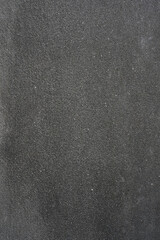 Obraz premium A dark grey concrete wall textured background. Vertical photo. Close-up, texture and detail, granular, hard, rough surface. Free space for copying. Industrial backdrop.