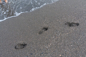 Gentle waves lap the shore at dusk on a tranquil beach in Málaga, Spain. Perfect for themes of relaxation, coastal serenity, and nature's beauty.