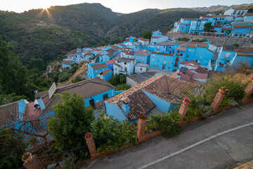 A tranquil alley in Júzcar, Spain, lined with vibrant blue buildings, capturing the unique charm of the 