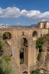  The iconic Puente Nuevo Bridge in Ronda, Spain, gracefully arches over the deep Tajo Gorge, with historic buildings perched on the cliffs. Perfect for themes of architecture, history, and travel.