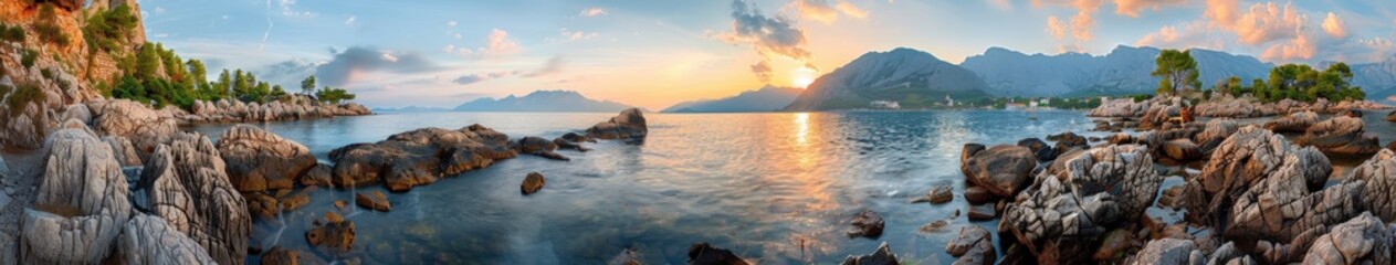 Fototapeta premium Rocky coastline and mountains at sunset in a serene landscape