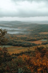 Misty autumn landscape in the mountains with vibrant foliage and hills