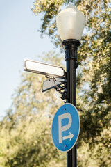Round blue P for Parking sign on a pole with a street sign above, copy space