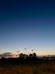 Twilight Construction: Urban Skyline with Cranes at Sunset