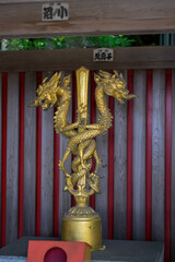 Japanese temple entrance with a golden sculpture on the garden