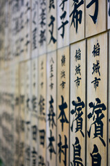 A row of plaques with Japanese characters in Takao Jinja Shrine on Mt Takao, Tokyo, Japan
