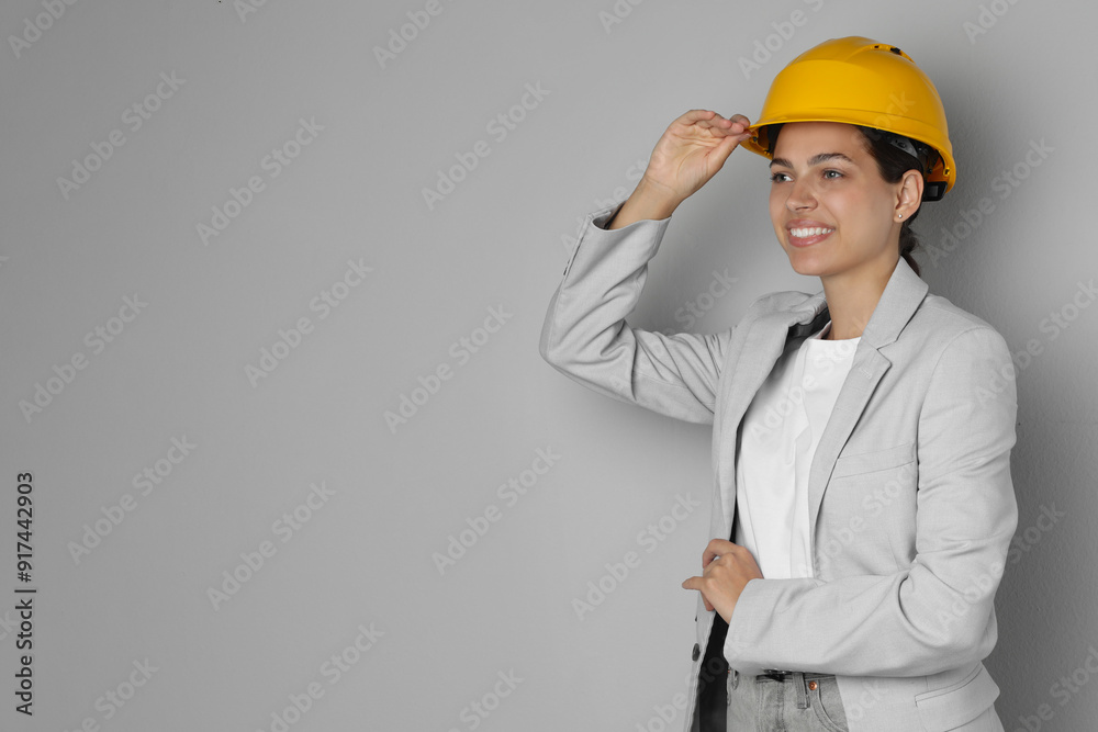 Wall mural Engineer in hard hat on grey background, space for text