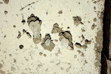 Detailed View of a Textured Plaster Wall With Weathered Patches and Exposed Layers in Natural Light