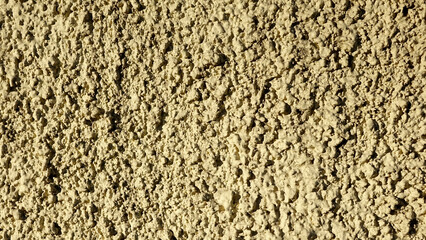 Textured Plaster Wall With a Rustic Finish, Showcasing Uneven Surface Details in Muted Tones