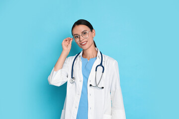 Smiling nurse in uniform on light blue background