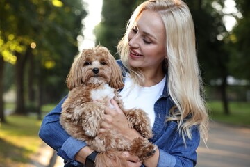 Beautiful young woman with cute dog in park