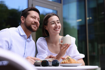 Happy couple having breakfast in outdoor cafe