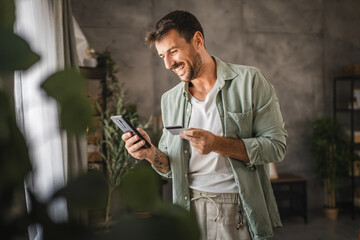 adult excited man have online shopping on cellphone with credit card