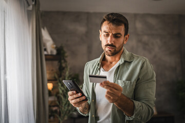 adult angry man have online shopping on mobile phone with credit card