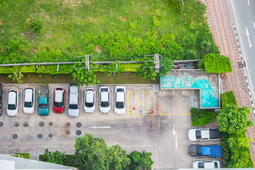 Top view of parking area with small garden in modern building.