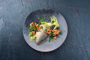Fried cod fillet with mashed potatoes, fresh prawns and marsh samphire served as top view on a...