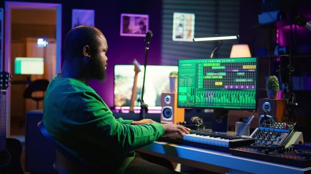 Musician playing piano keyboard and recording tracks for mix and master session, using digital software on pc to create new songs. Sound producer composing music with midi controller tool. Camera B.