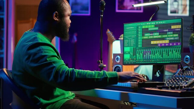 Artist playing piano electronic keyboard and recording new sounds, producing new midi controller notes in his home studio. Audio producer working with digital audio workstation software. Camera A.