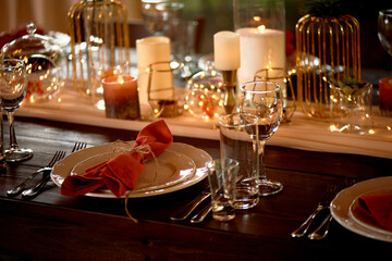 Table setting with orange napkins and glasses. Classic. Warm shades.