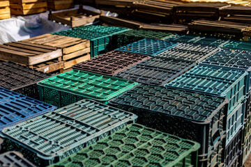 Fototapeta premium This photo depicts a stack of colorful plastic and wooden crates arranged in an orderly manner, likely used for storage or transportation in an industrial or agricultural setting