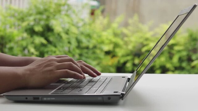 Close up of freelancer's developer hands typing program code on laptop keyboard in coworking. Businessman at work in working in cafe. Copywriter writing text on computer keyboard in coffee shop.