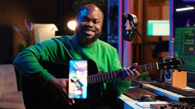 Talented performer teaching how to play acoustic guitar online for a tutorial, hosting internet master class to provide advice for beginners. Artist composer explaining accords on strings. Camera A.